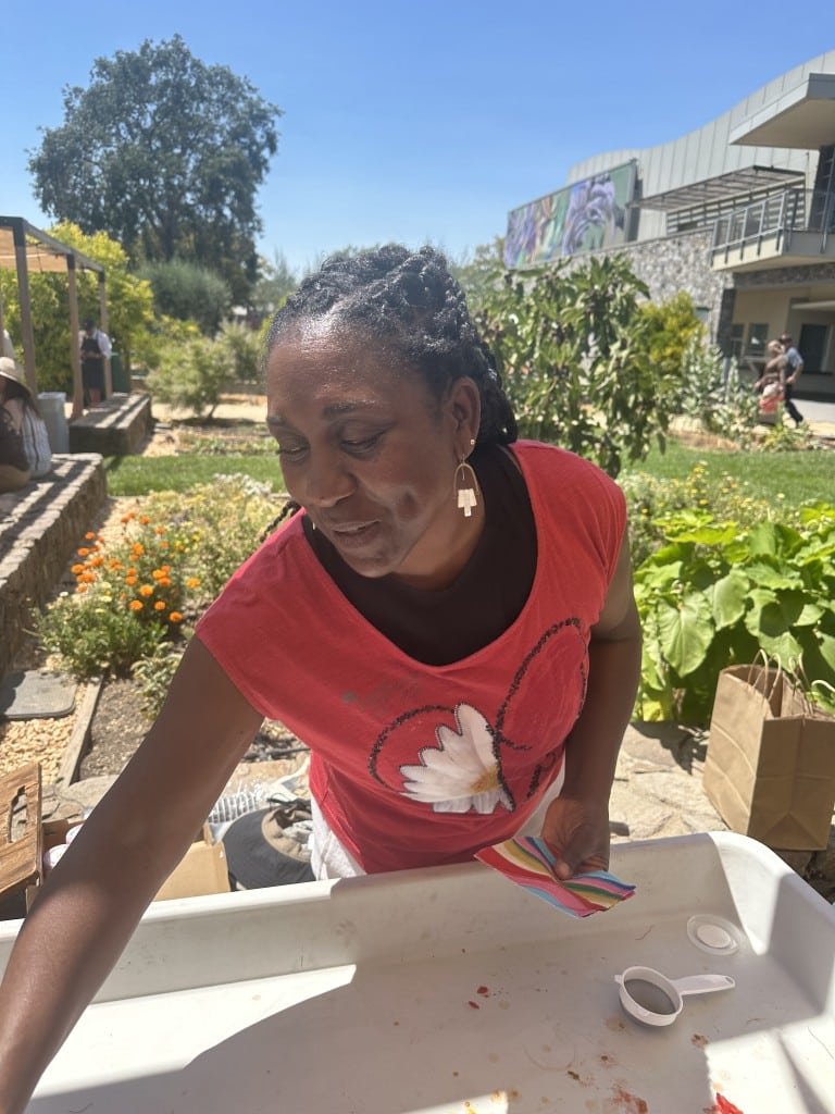 Lauren Buffaloe–Muscatine demonstrates seed saving at Tomatoganza! 2025. Lisa Adams Walter photo