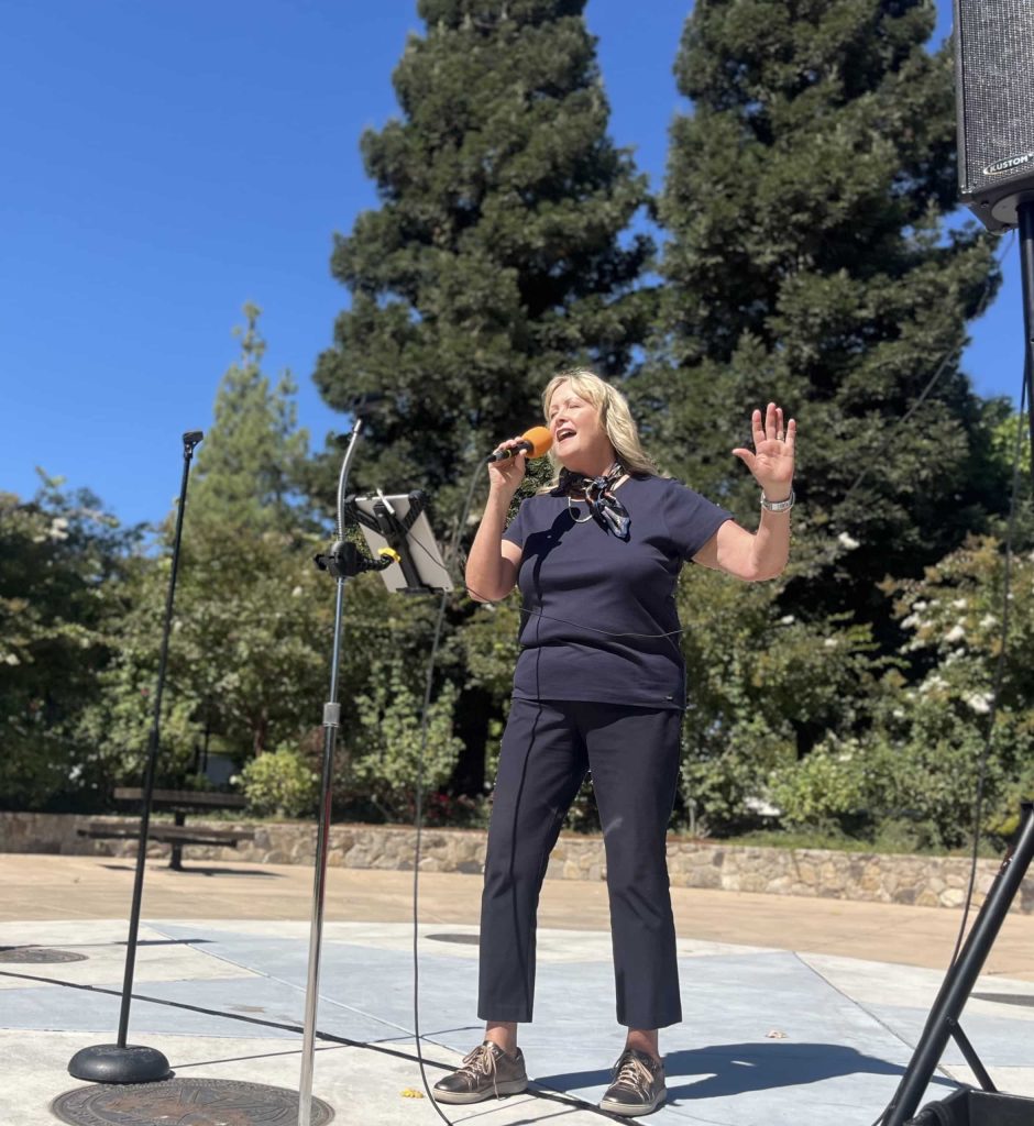 Yountville Vice Mayor Robin McKee leads rally-goers in a rendition of The Youngbloods' 1967 song "Get Together." Griffin Jones photo