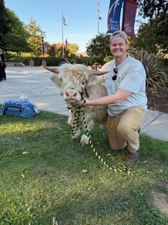 Kellen McAllister of Lyon Ranch with a miniature Scottish Highland cow. Susan Wiechers photo