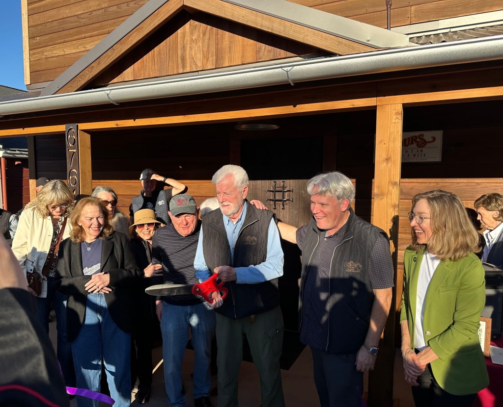 Ren Harris swiftly cut the purple ribbon to officially open Pancha's with partners Paul Frank on his right (in ball cap) and Scott Lewis on his left. Lisa Adams Walter photo