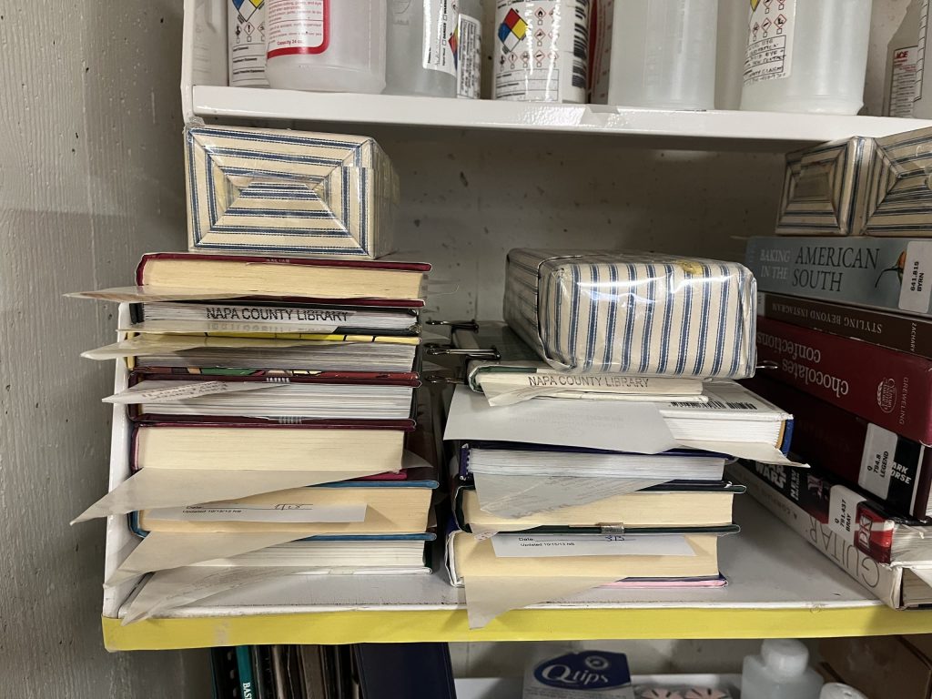 Books that have been repaired at the Napa County Library are weighted down by bricks wrapped in a blue-striped cover. Anthony Halstead photo
