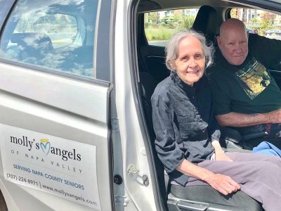 two elder adults in a van